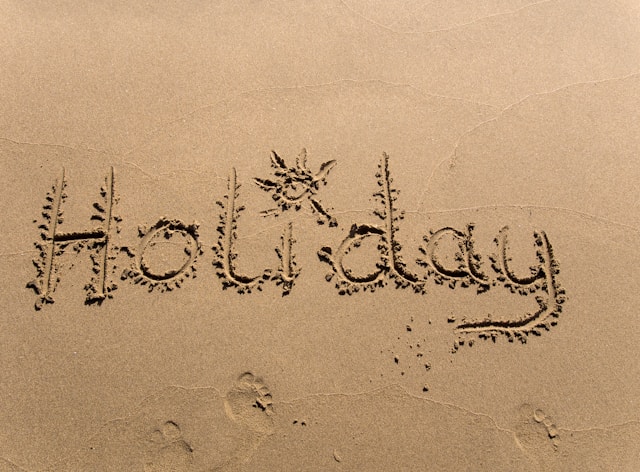 Das Symbolbild zeigt Holyday in Sand geschrieben und steht für Sommerferien